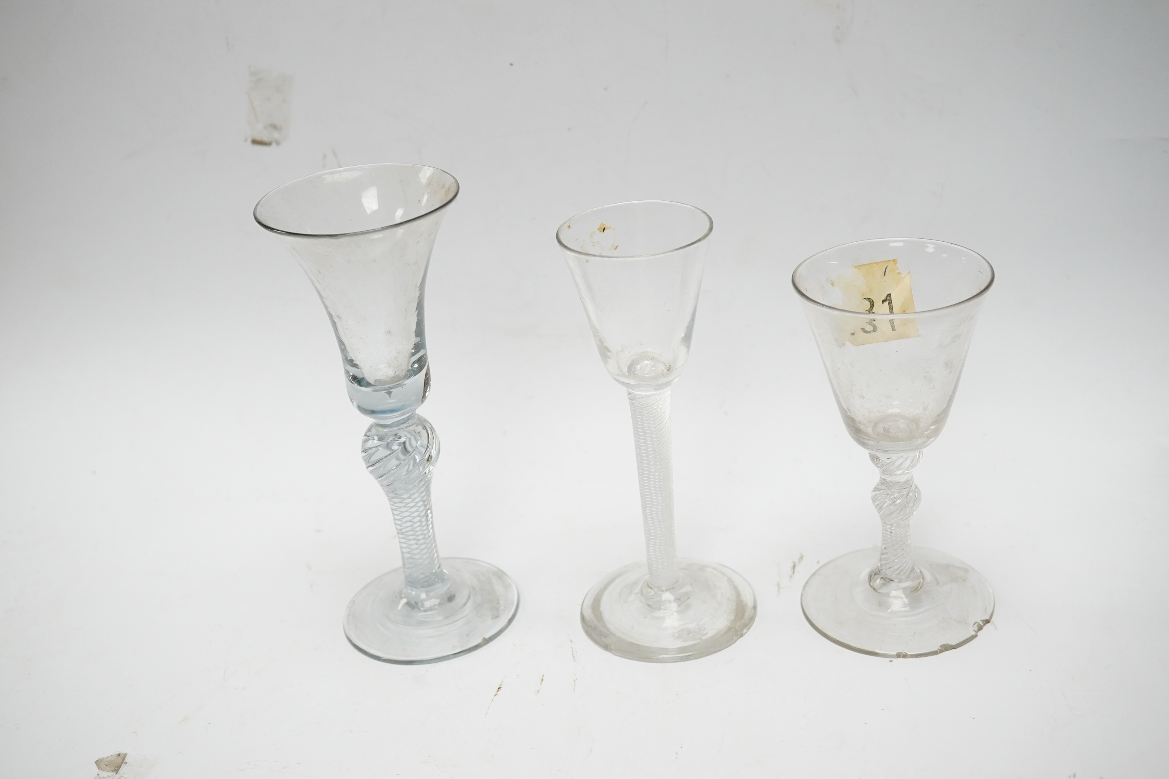 Three 18th century air twist stemmed wine glasses, tallest 16.5cm high. Condition - two having chips to edges of bases